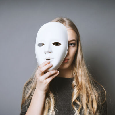teen girl hiding face behind mask